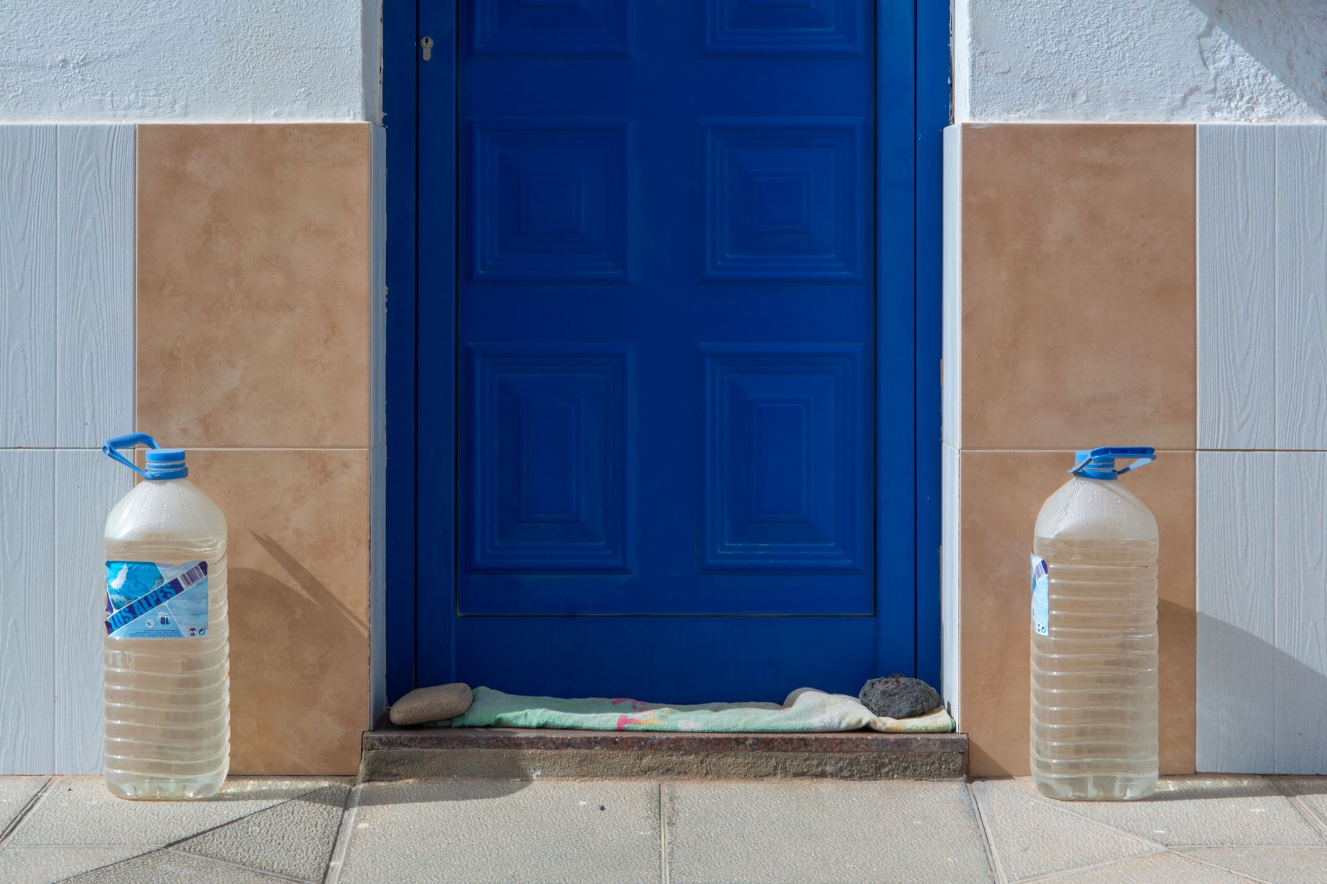 Apartment closet with stacked blue water bricks and a portable water filter