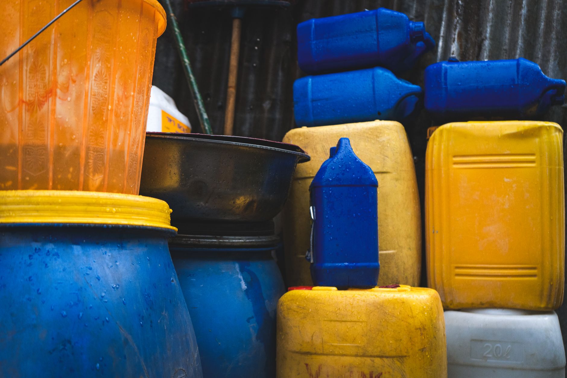 A 55-gallon blue water storage drum with pump in a home basement