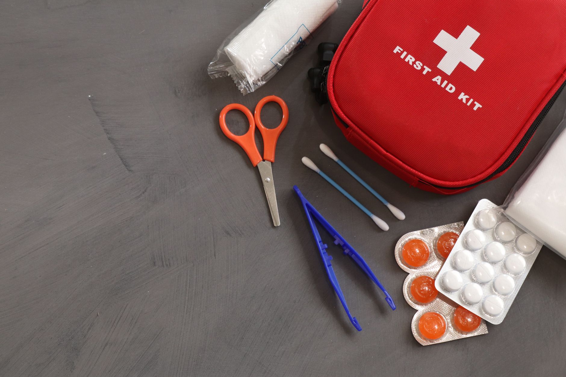 A basic emergency kit with water bottles, flashlight, and first aid supplies