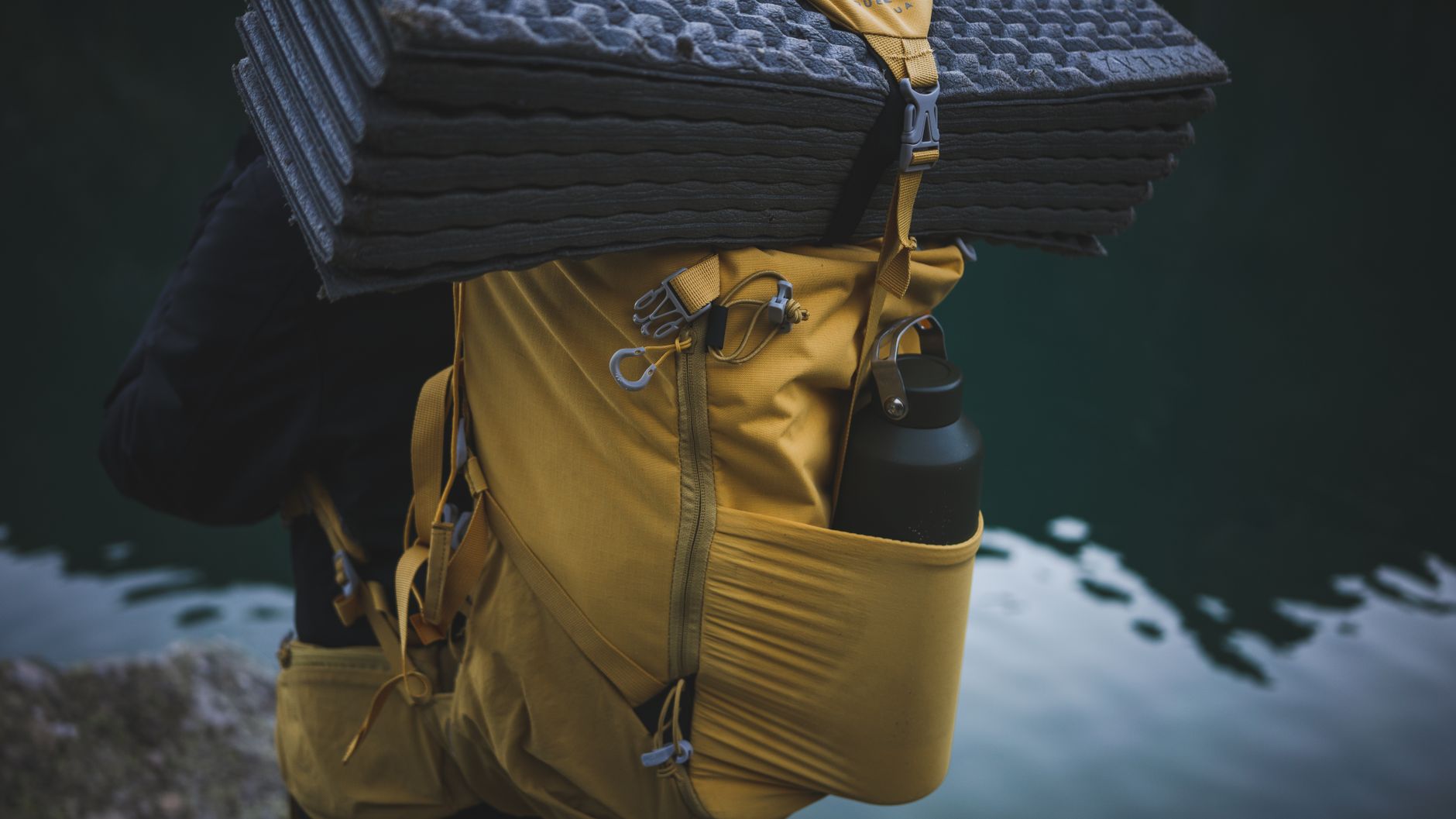A portable water filter, collapsible bottle, and purification tablets laid out on a table.