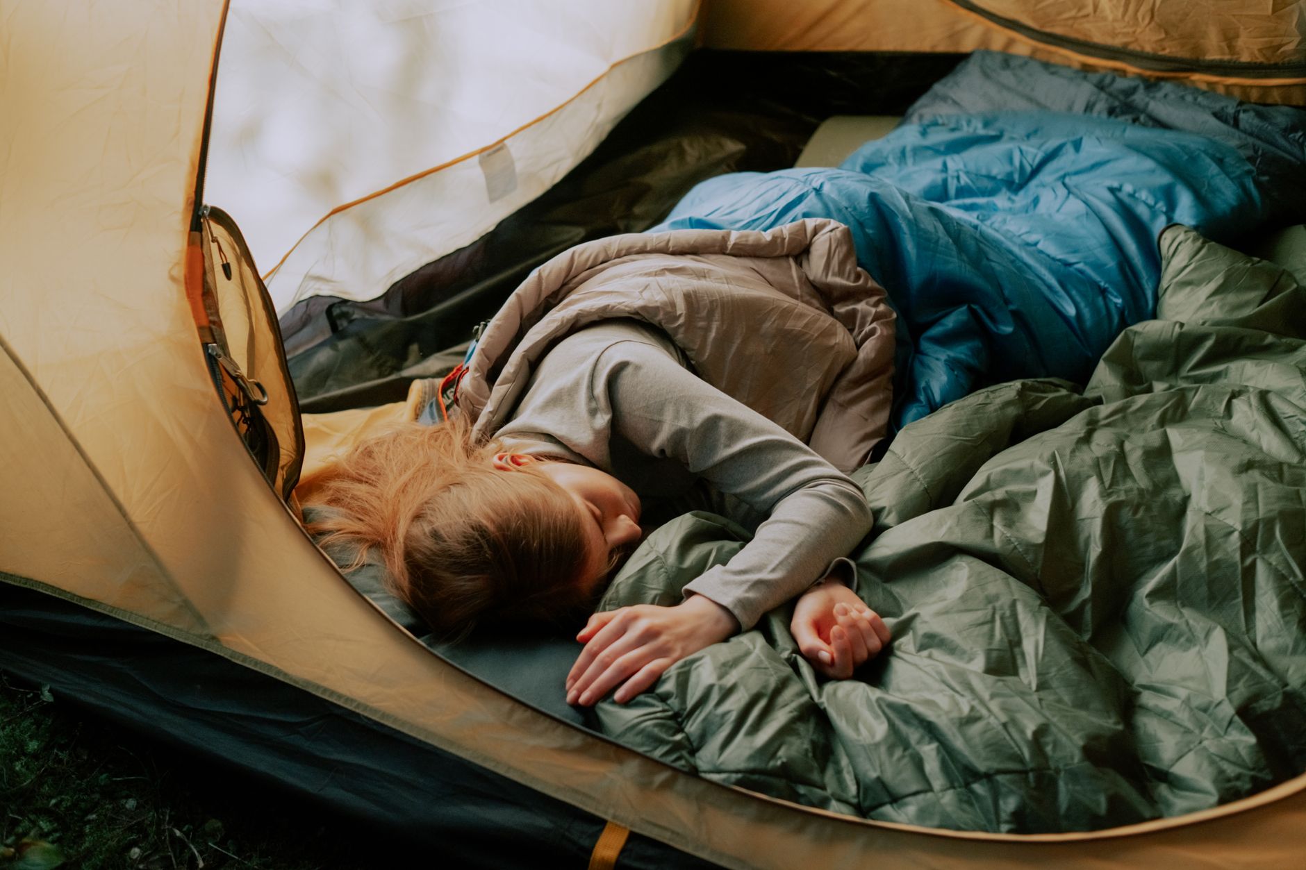 Silver emergency sleeping bag opened on ground in cold weather