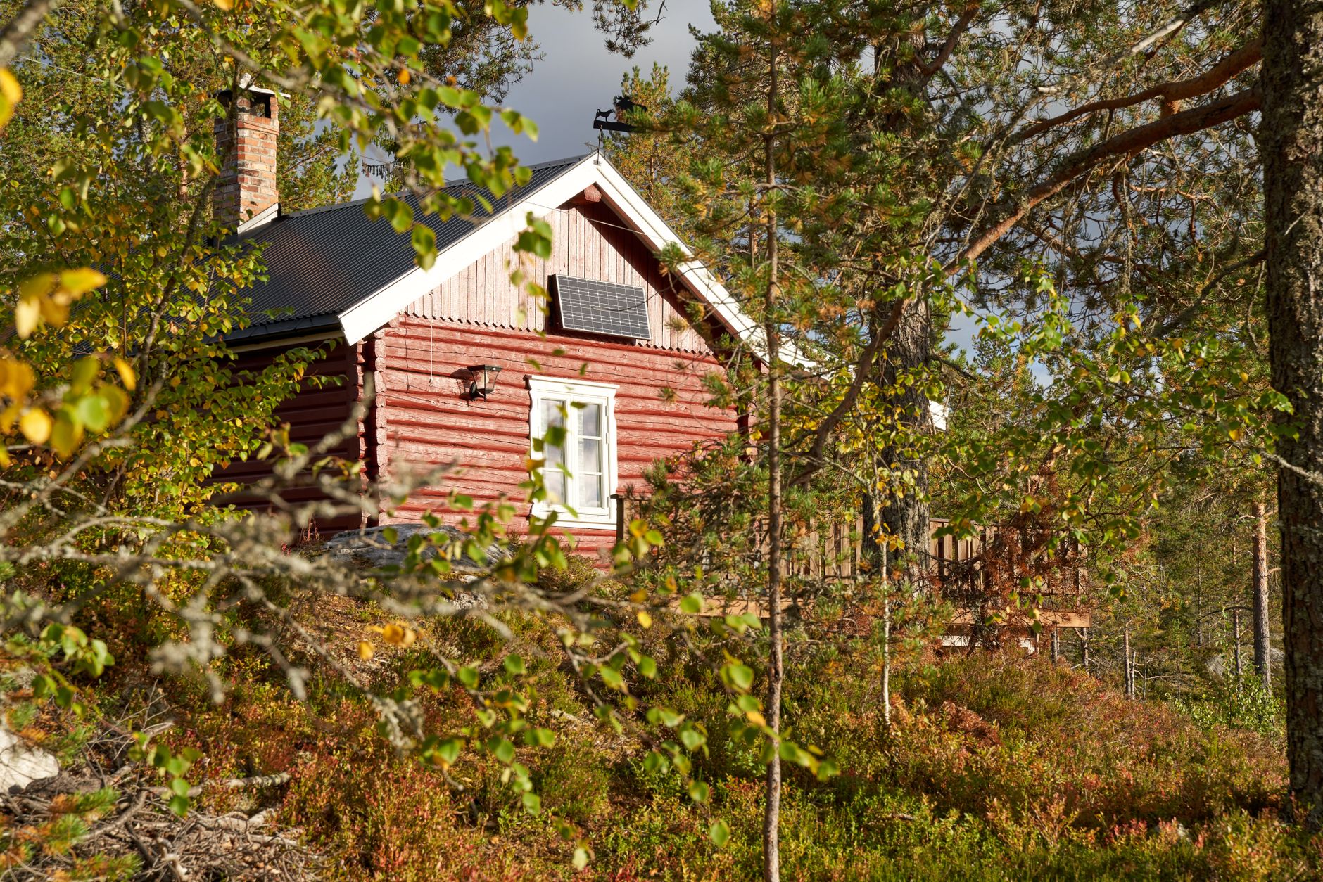Solar panel array and battery bank beside a remote off-grid cabin