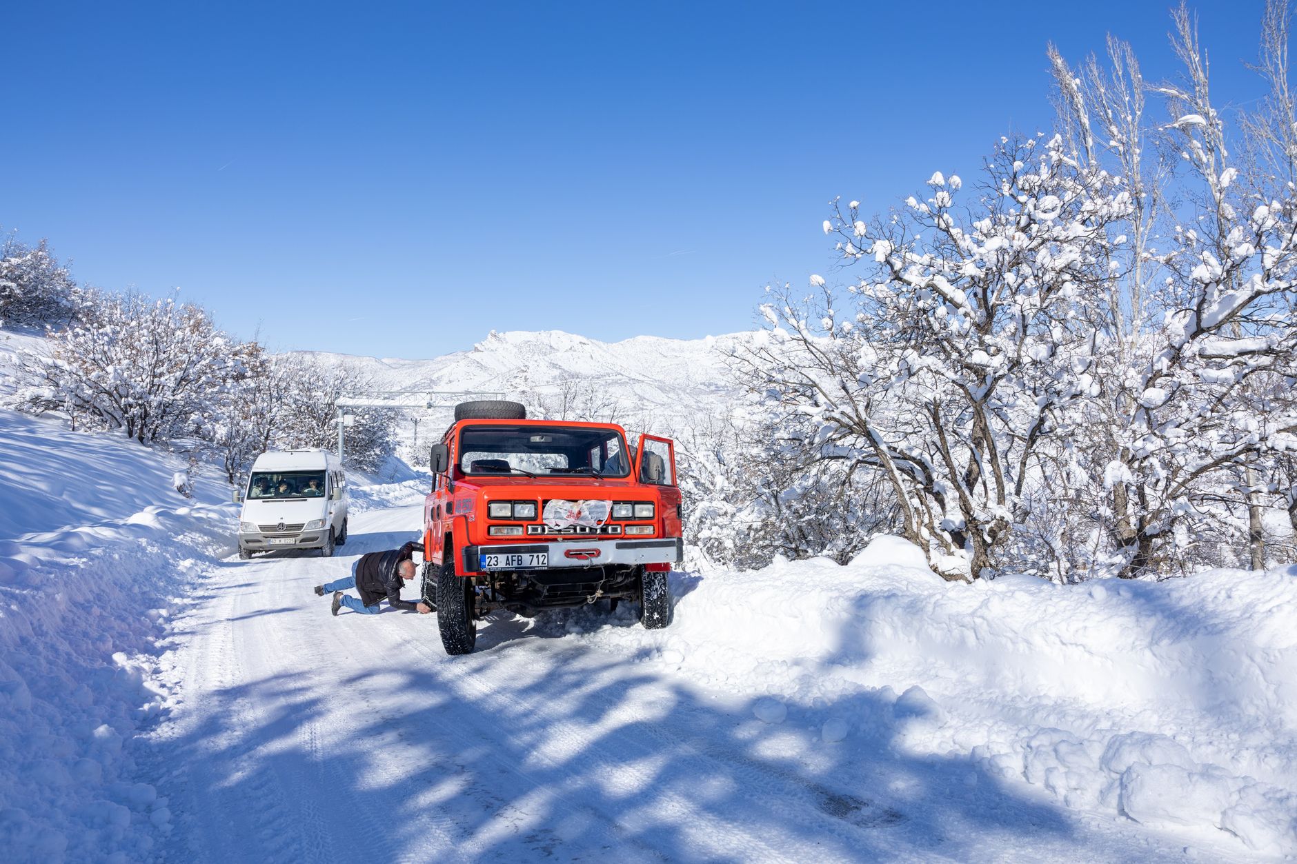 A well-organized winter car survival kit with blankets, flashlight, first aid, food, and water